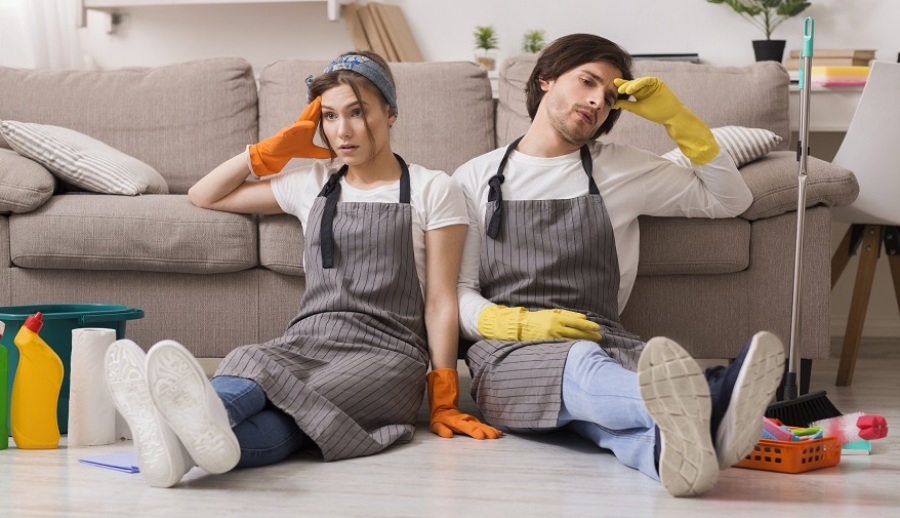 Exhausted Couple Sitting on Floor After Cleaning Apartment