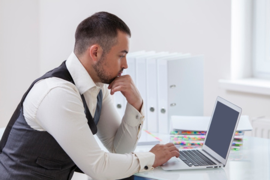 Young Businessman Looking at Laptop