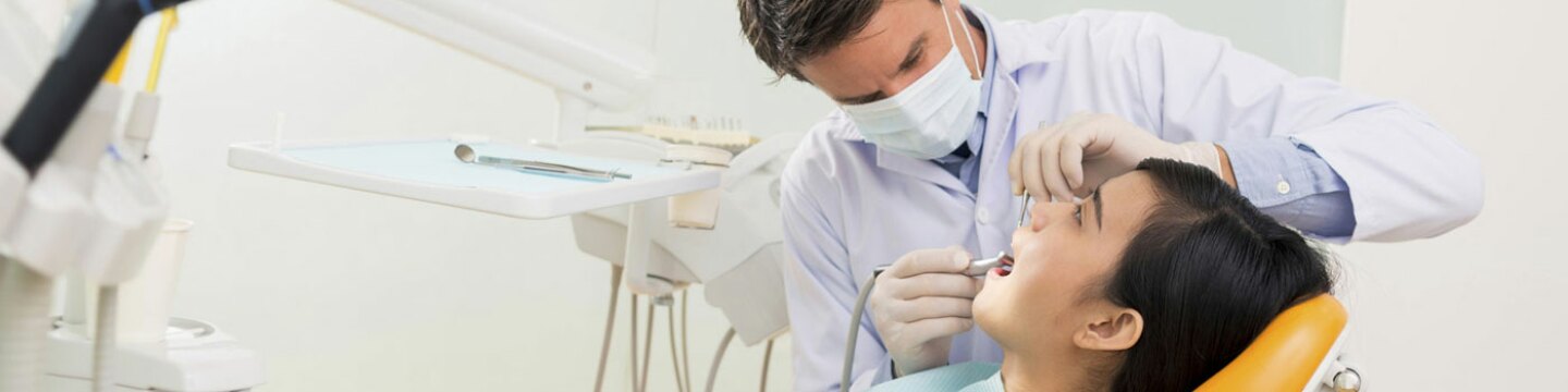 Persona joven sentada en el dentista recibiendo tratamiento dental