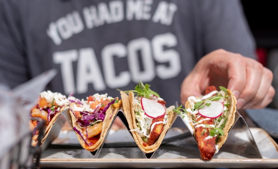 Person eating tacos. Saying the the person's shirt reads, "You Had Me at Tacos."