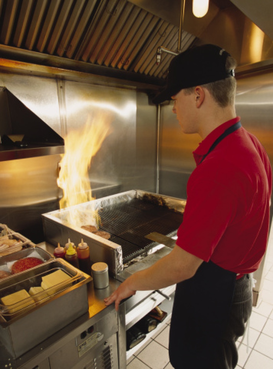 Fast Food Worker Flipping Burgers