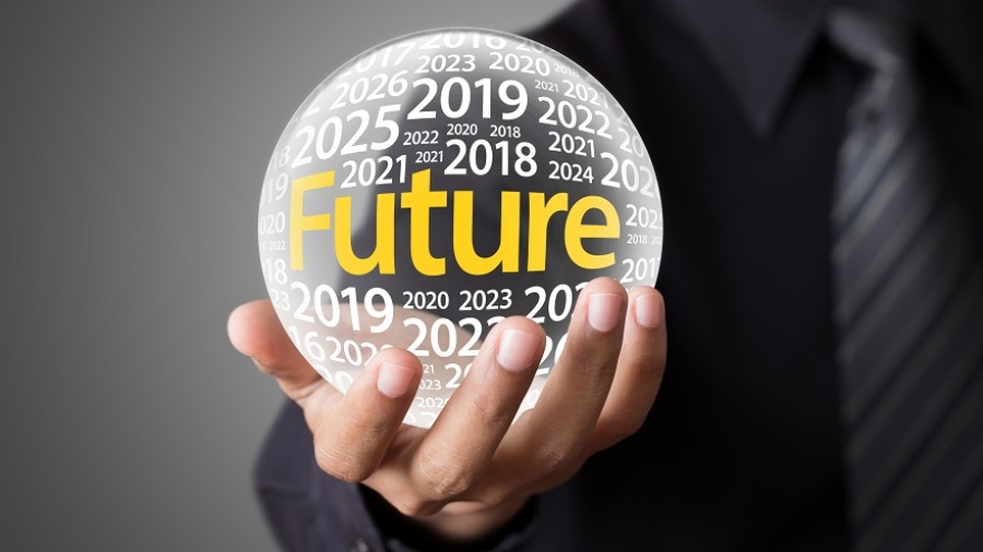 Hand of businessman holding crystal ball that says "future" in yellow with upcoming years surrounding the word in white.