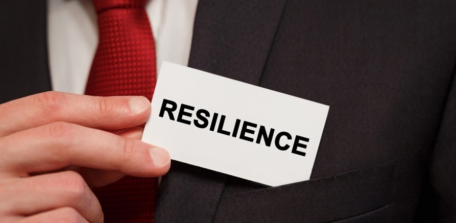 Businessman putting card with word "resilience" on it into suit pocket.