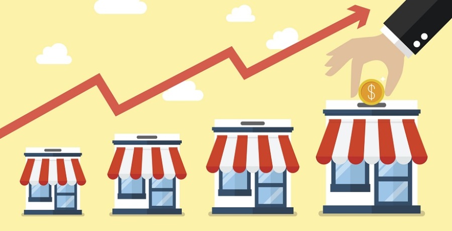 Illustration of multiple franchise shops with a line graph indicating increased profit. There is a person's hand putting a coin the rightmost shop like a piggy bank.