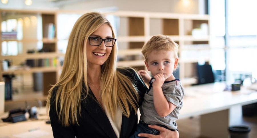 Mother in business attire holding young son.
