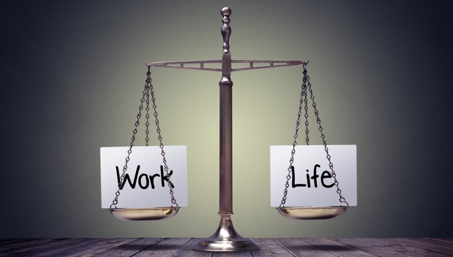 Scale on a wooden table showing work-life balance.