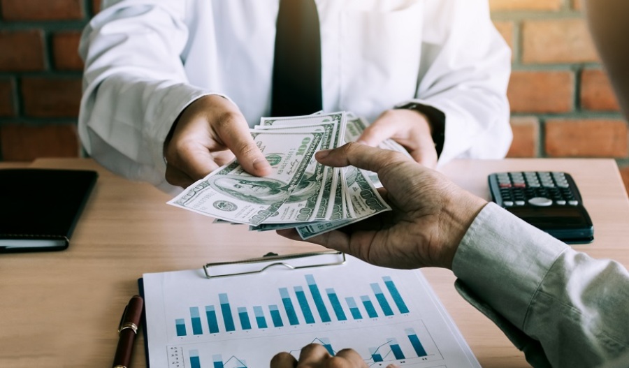 Businessman giving money to business partner.