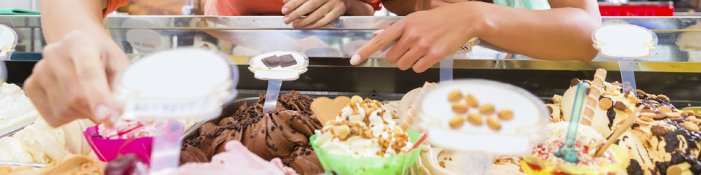 Gente eligiendo sabores de helados en una heladería
