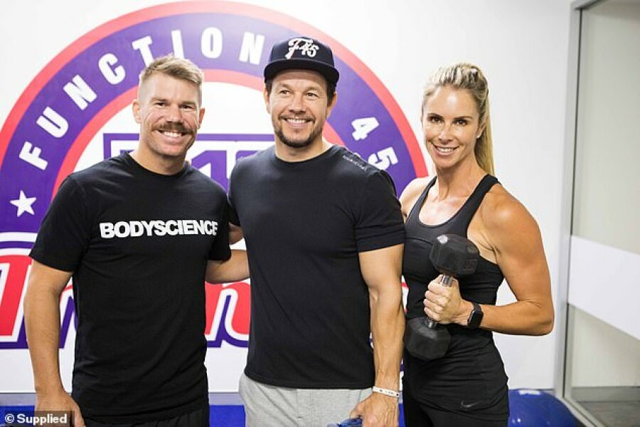 Working hard! Celebrities including David Warner (left), Candice Warner (right) and Elle Ferguson flocked to an F45 gym in Sydney to train with Mark Wahlberg (centre) on Tuesday