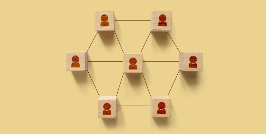 Wooden block cubes with icon humans on background connected by lines.