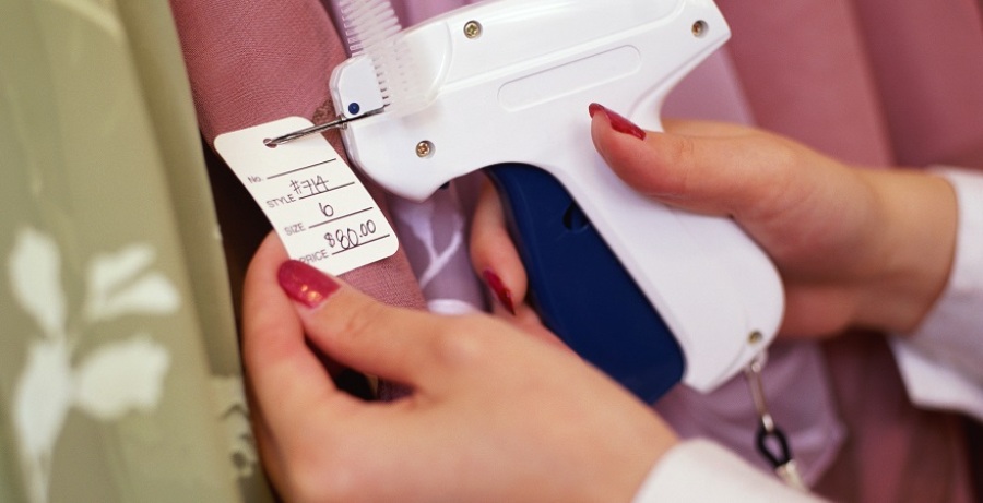 Woman attaching price tag to a garment.