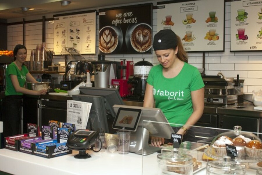 Cashier at the counter of a coffee and juice bar.