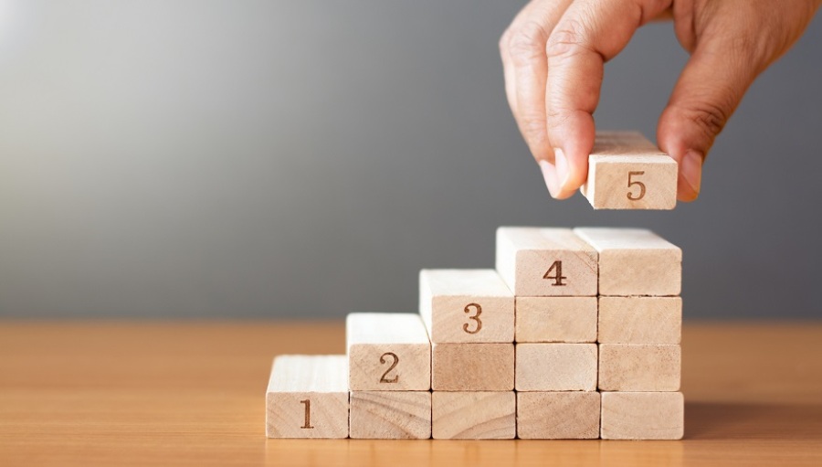 Hand arranging blocks numbered 1 to 5.