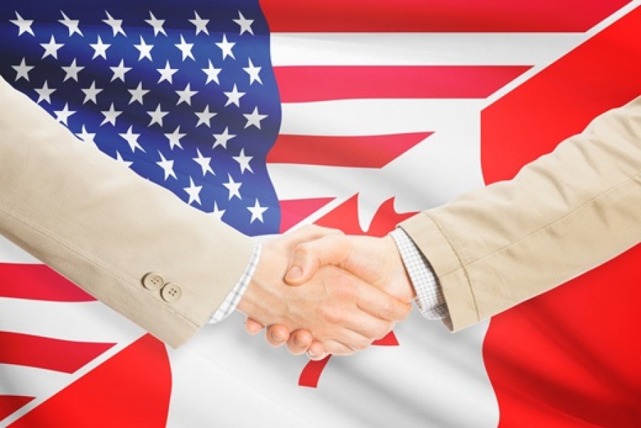Handshake with US and Canada Flags in Background