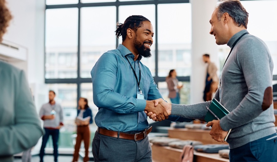 Two male entrepreneurs shaking hands at a business conference.
