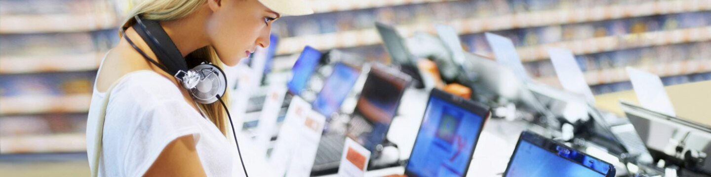 Mujer mirando laptops en una tienda de equipo tecnológico