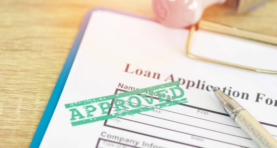 Loan application form with a green "approved" stamp.